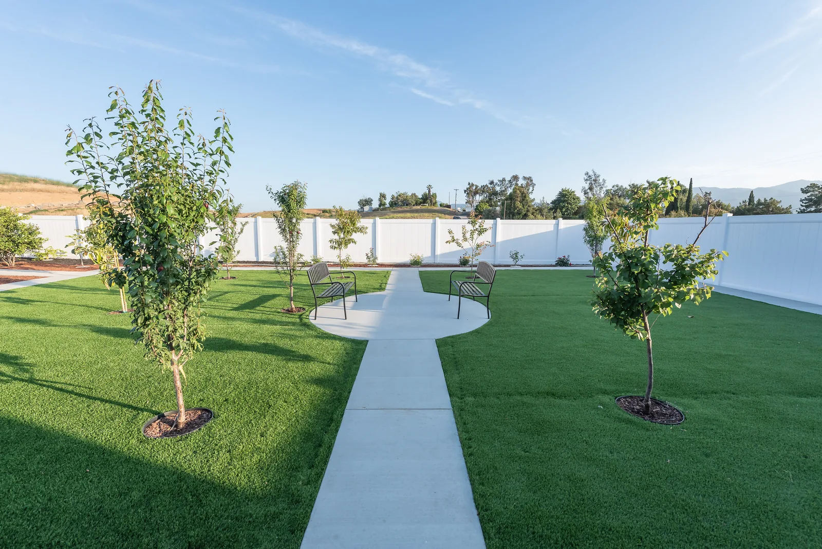 Garden path with fruit trees and mountain views where residents walk each day at Manitou Home